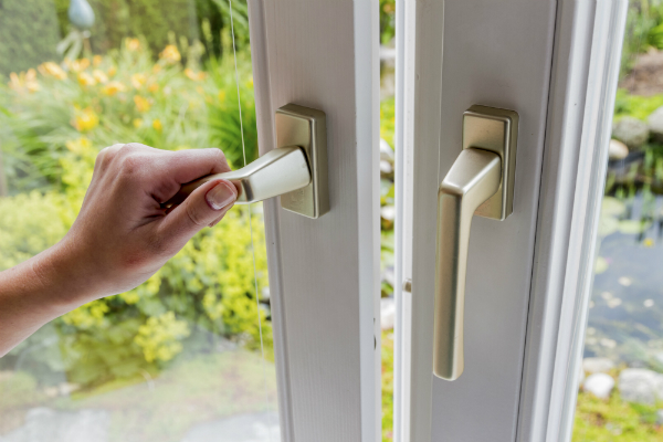 Frau oeffnet Fenster zum Lueften