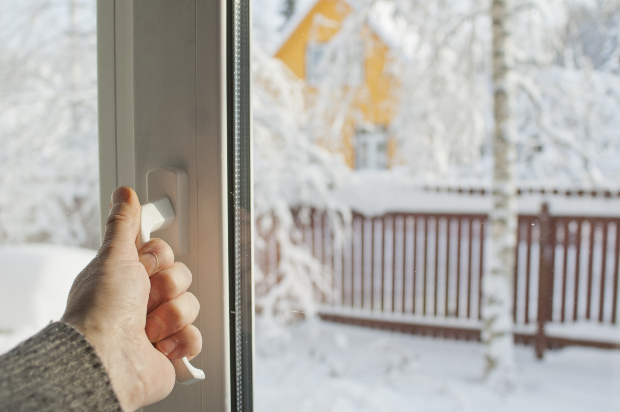 Hand greift zum Fenster, um es zu öffnen