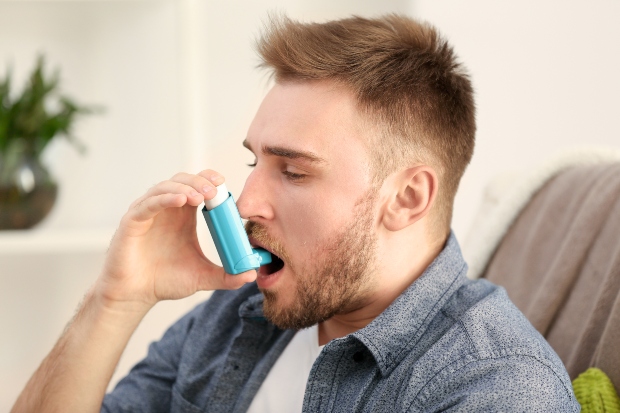 Mann mit Asthma Spray - Gesundes Wohnen mit Schimmel ist kaum möglich