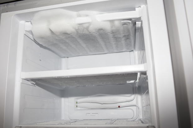 Eisfach eines Kühlschranks mit einer Menge gefrorenen Wassers 