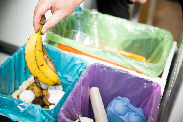 Bananenschale wird in Abfallbehälter geworfen