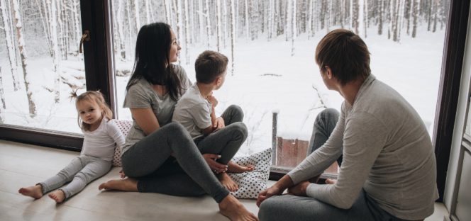 Familie sitz im Winter am Fenster