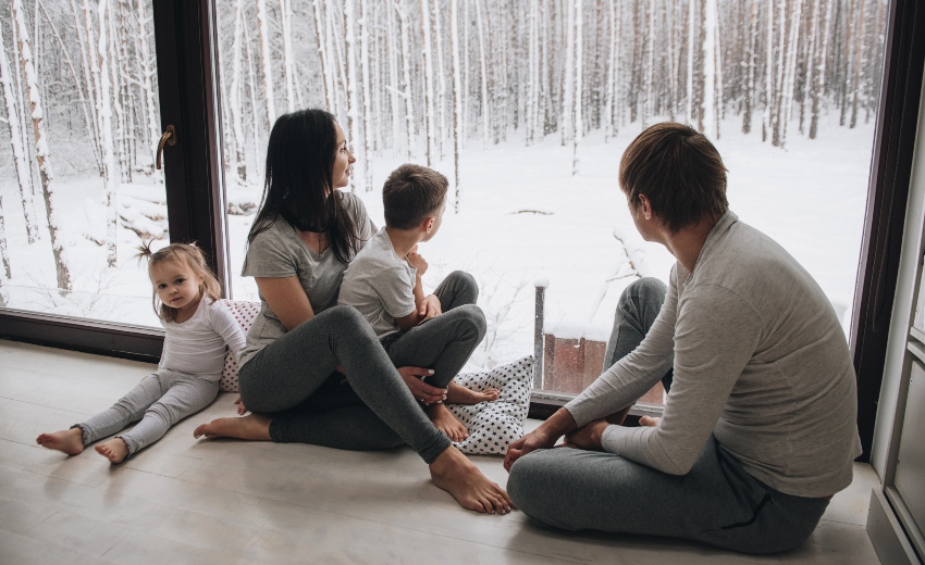 Familie sitz im Winter am Fenster