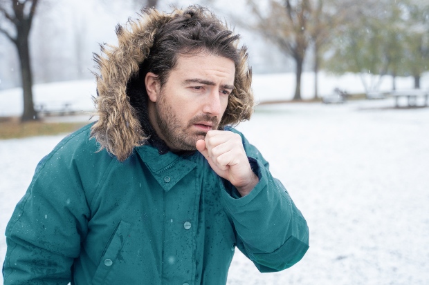 Mann im Winter hustet - Trockener Hals tritt häufig bei niedrigen Temperaturen auf