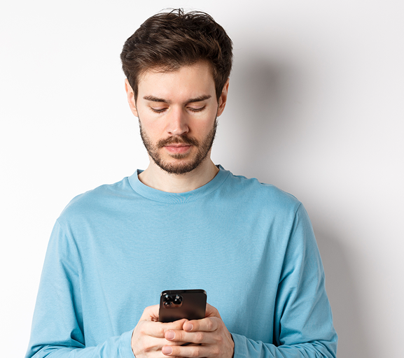 serious young man reading message smartphone looking mobile screen standing white backgro 1 019f6409